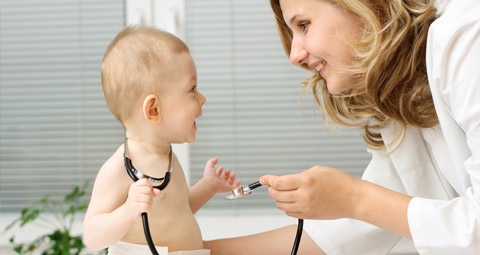 Doctor showing a stethoscope to a baby